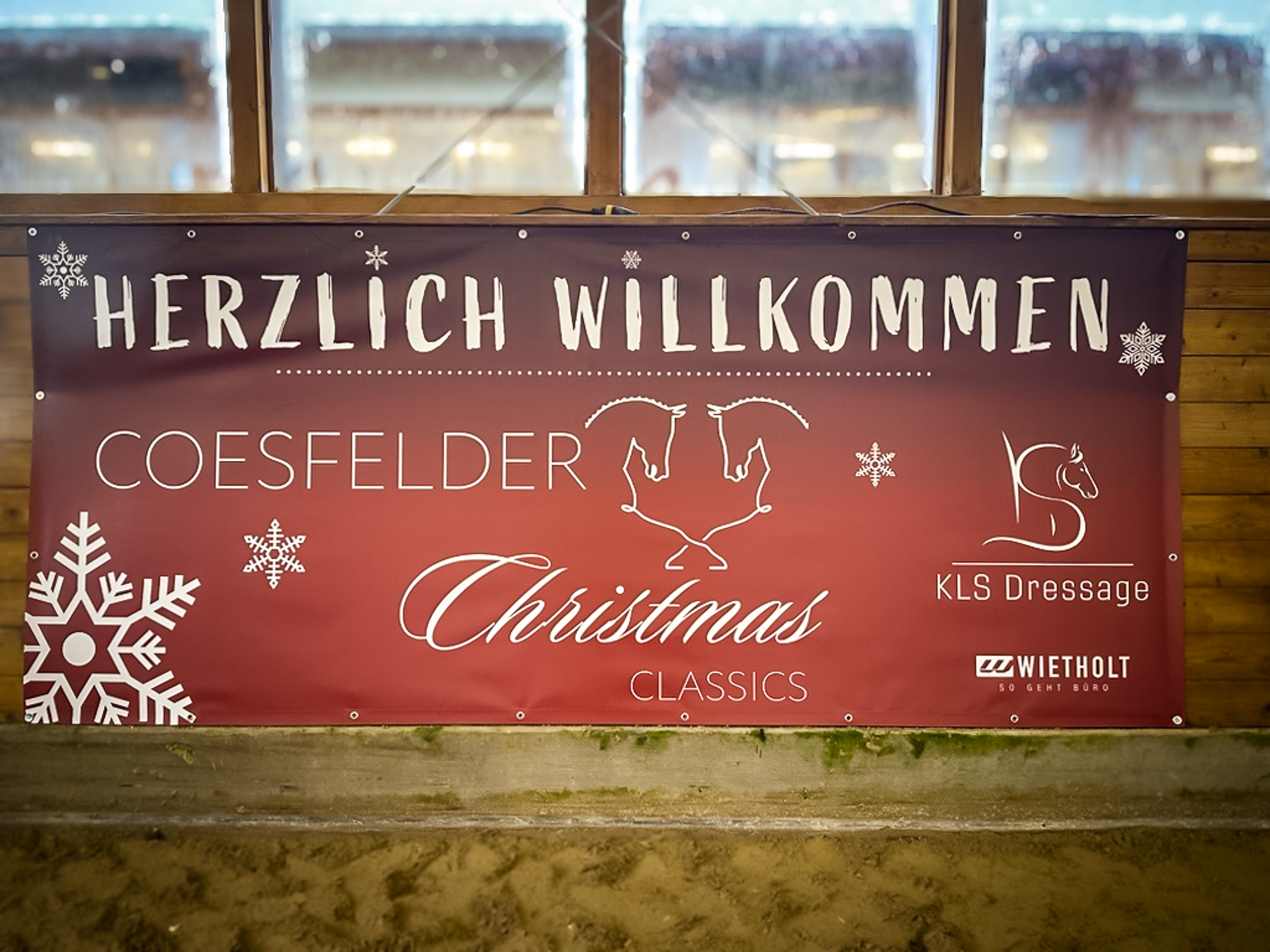 Rotes Veranstaltungsbanner mit weißer Schrift der Coesfelder Christmas Classics mit Wietholt als Hauptsponsor